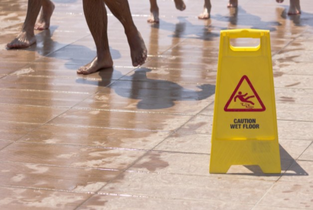 people walking on slippery surface near slip and fall sign